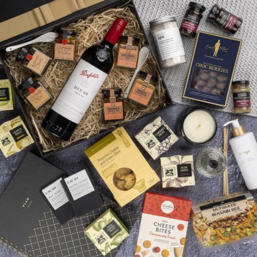 A carefully chosen collection of props forms a visual tapestry around a gift hamper, creating a sense of occasion and celebration. Discover a captivating collection of items within the gift hamper, each one thoughtfully chosen to create a truly remarkable experience, taking the recipient on a journey of delight and surprise, a gift that brings a sense of wonder and awe. This gift hamper contains: Desert Sauce; Chutney and Pastes; Hand Cream; Red Wine; Chocolate; Candles; Crackers; Diffuser; Antipasto; Skincare; Mustards and Dressings; Biscuits; Nuts; Planners
