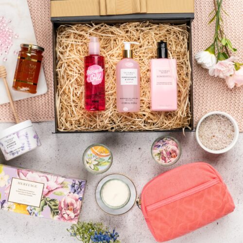 An artful arrangement of props weaves a story of anticipation and surprise in this captivating flat-lay photograph. Inside the gift hamper, you'll discover a carefully curated collection of exquisite items, each one a testament to luxury and elegance, ensuring a remarkable gift-giving experience that will be cherished and treasured, creating moments of pure happiness and pure indulgence. This gift hamper contains: Candles; Honey; Body Wash; Body Lotion; Make Up Bag; Body Scrub; Hand and Body Lotion