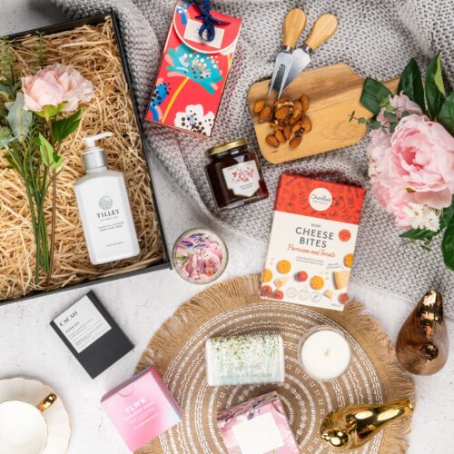 A carefully chosen collection of props forms a visual tapestry around a gift hamper, creating a sense of occasion and celebration. Explore the gift hamper to find a delightful assortment of surprises, guaranteed to bring joy and excitement. This gift hamper contains: Bath And Shower Gel; Biscuits; Chocolate; Candles; Soap; Jam; Hand Cream; Body Wash